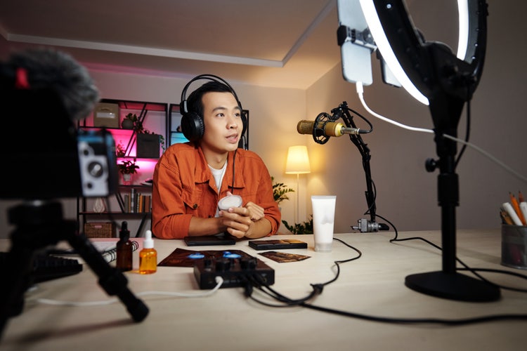 Man using microphone and ring light at desk