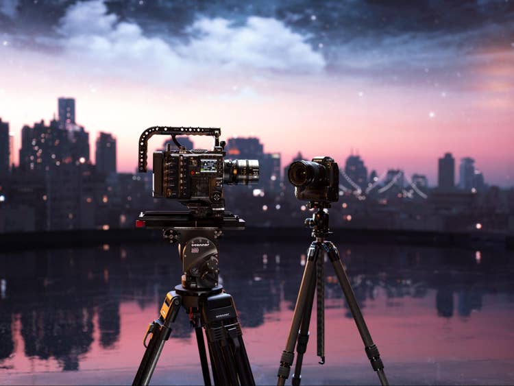 Image of two cameras on tripods with a skyline in the background.