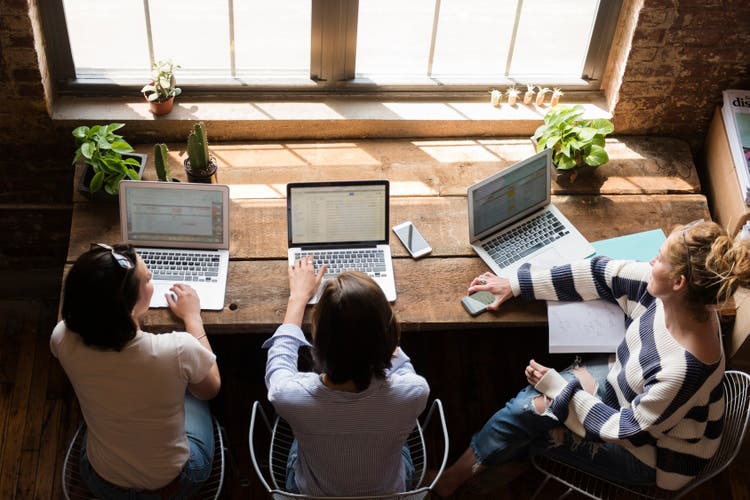 Image of colleagues working on laptops.