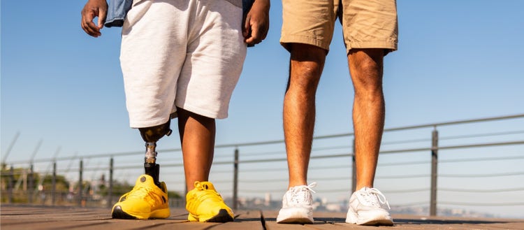 Man with prosthetic leg walking with friend.