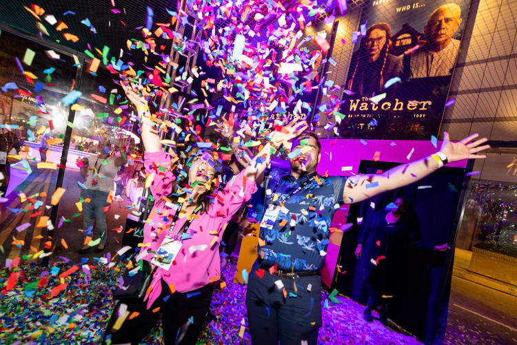 Adobe MAX goers play with confetti in the community pavilion.