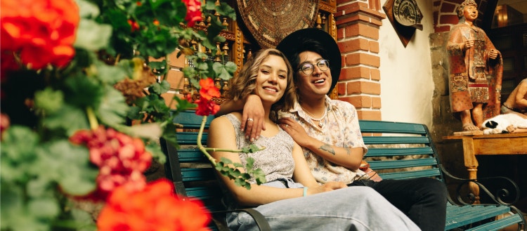 Two people sitting on a bench.
