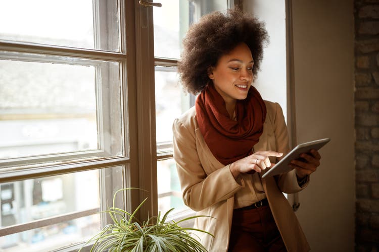 Woman on workplace taking information from iPod.