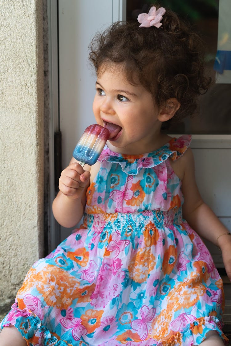 Image of a small child eating a popsicle.