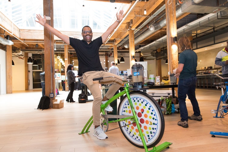 Damon Guidry riding a bike during an Adobe wellness event.