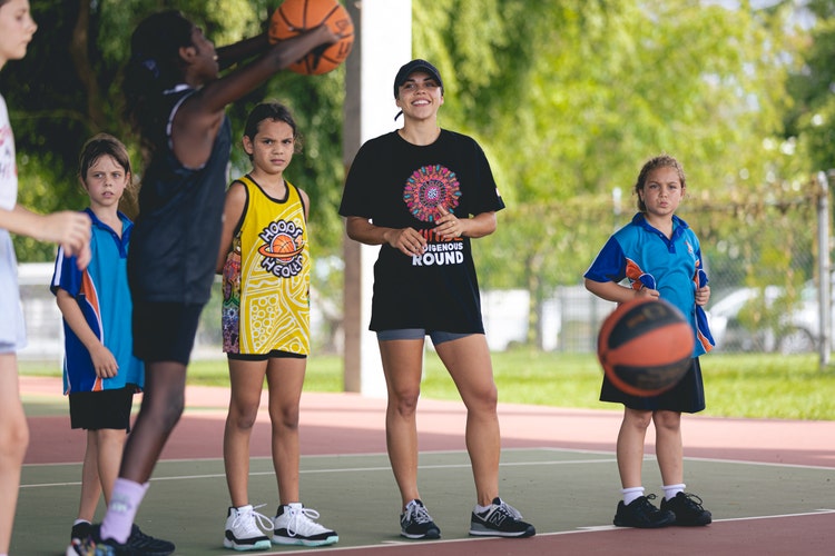 Abby Cubillo playing basketball with children for Hoops 4 Health