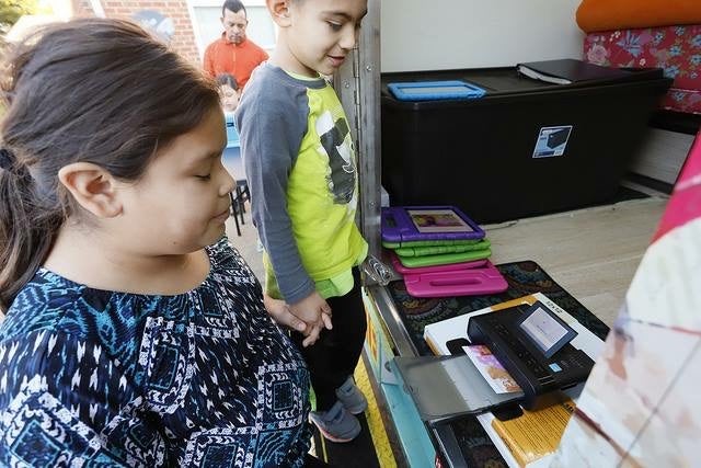 Children looking at a printer.