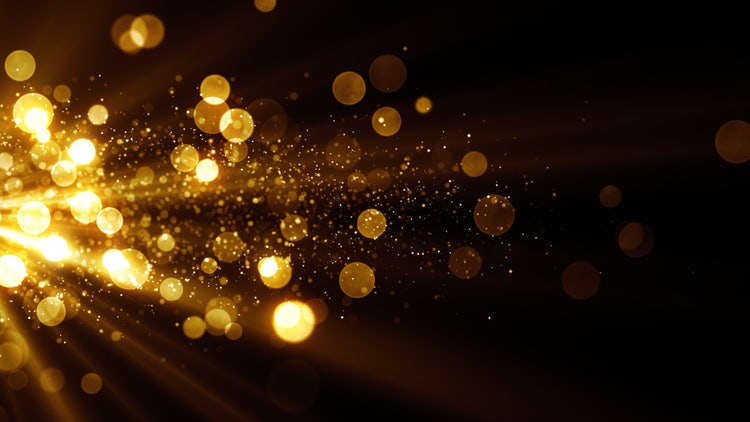 Glitter celebration texture. Golden stream with particles. Abstract background with magic lights and sparks.