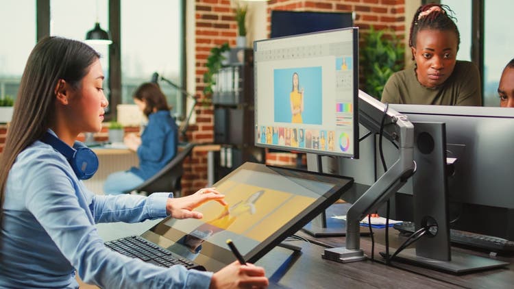 Women at a desk creating digital content.