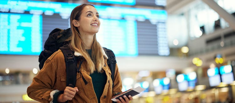 Girl traveling, looking around holding a device.