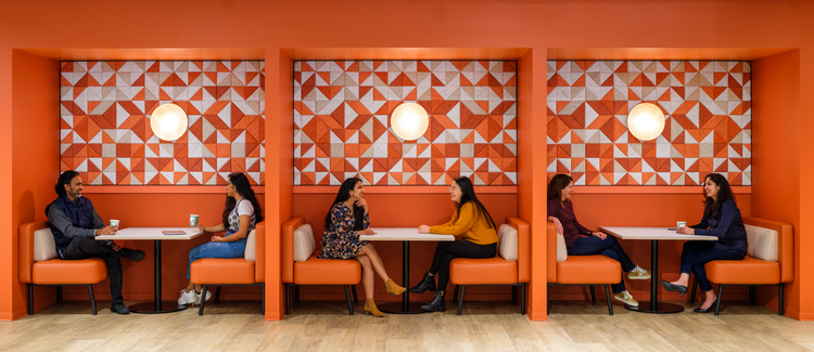6 people sitting in booths with an orange background.