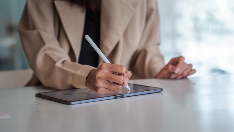 Close up of businesswoman hand are working on the tablet at office.