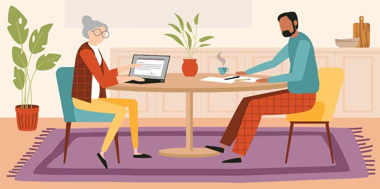 Two people sitting at a table going over documents.