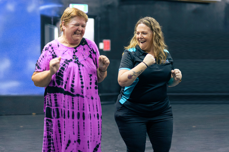 NADO support worker and participant dancing and laughing