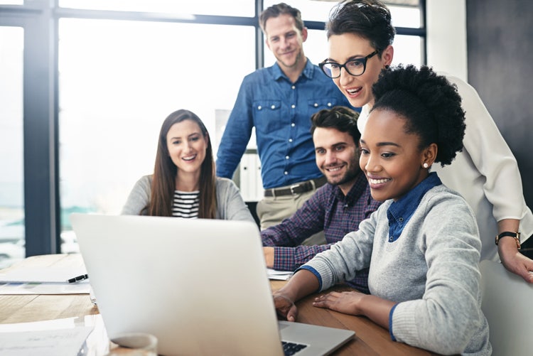 Group of people looking a laptop screen.