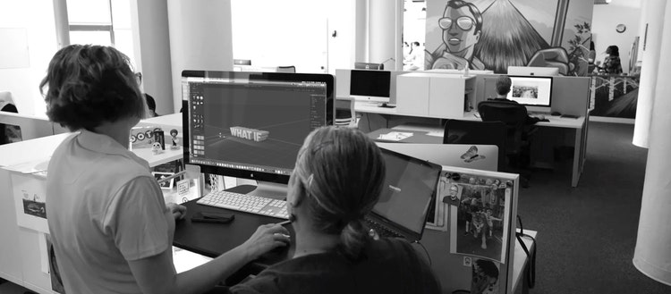 People looking at a computer using Adobe Substance 3D Stager.