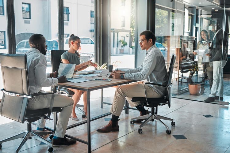 Group of people meeting around a desk.