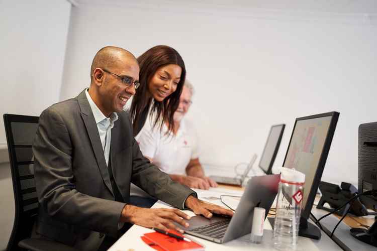 Two people looking at a computer screen together.