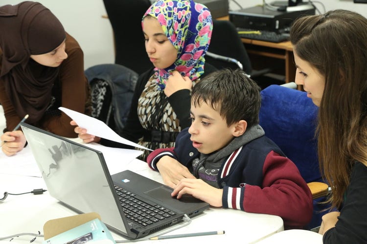 Image of students working on a laptop.