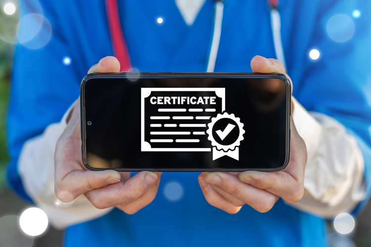 Image of a medical professional holding phone with certified screen on the phone.