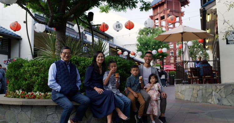 Joshua and John Morrey and family sitting on bench.