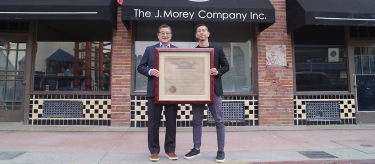 Joshua and John Morey standing in front of The J.Morey Company Inc. building.