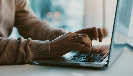 Image of a person typing on a laptop