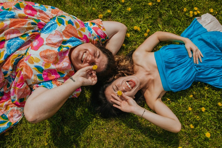 Image of two woman laying on the grass from the Calming Rhythms trend.