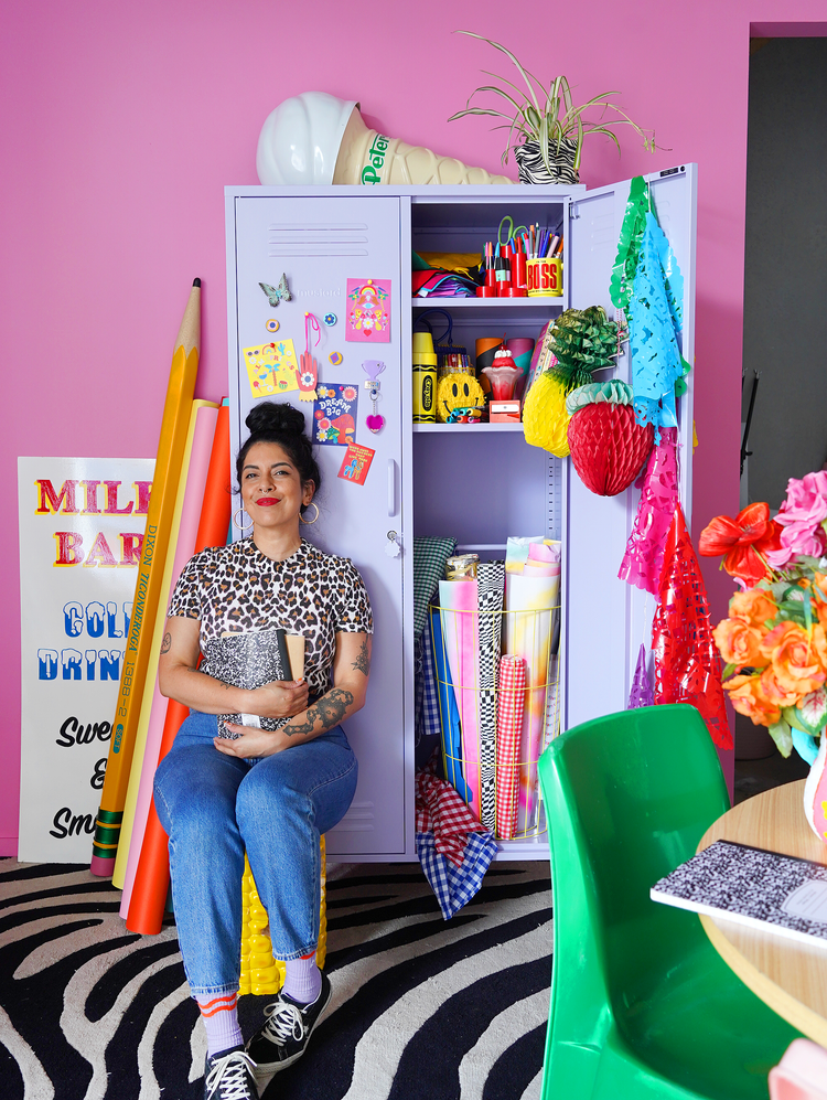 Kitiya Palaskas in her studio surrounded by her paper crafts, prop installations and fabrics.