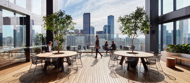 Photo of rooftop patio with tables and professionals working.