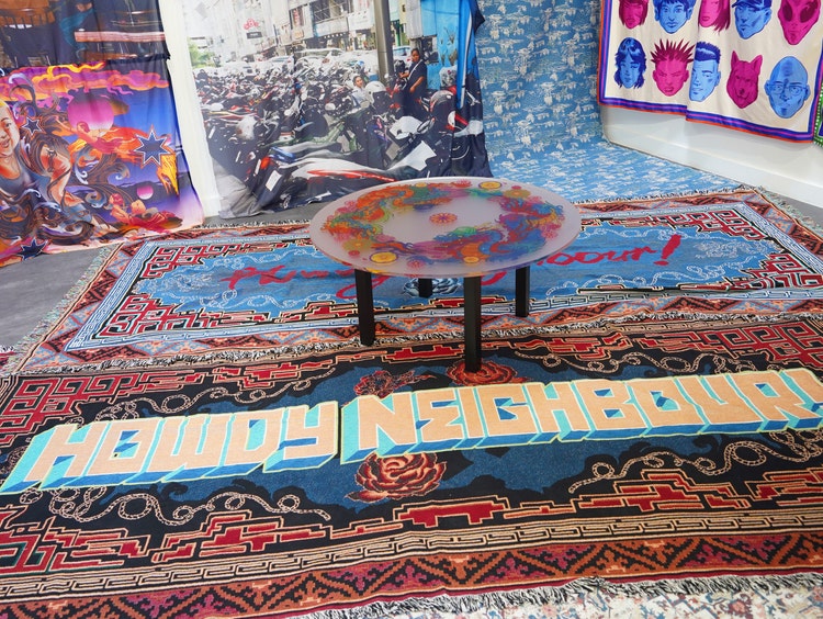 Rug with bold pattern and hanging tapestries at art exhibition