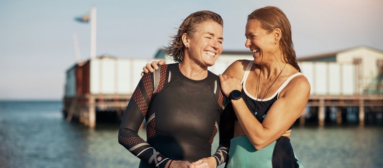 Image of two women smiling in swimsuits.