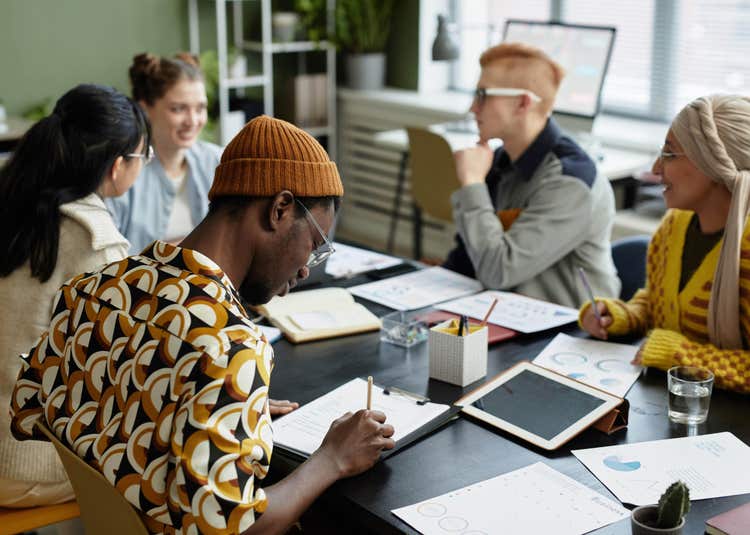 Group meeting a desk.