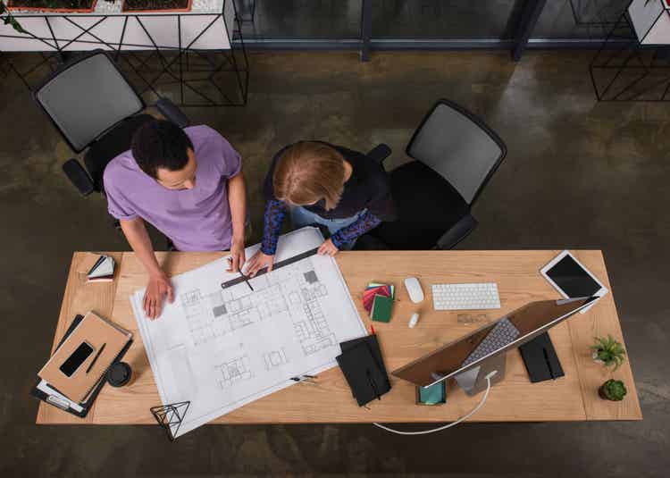 Two people working on blueprints.