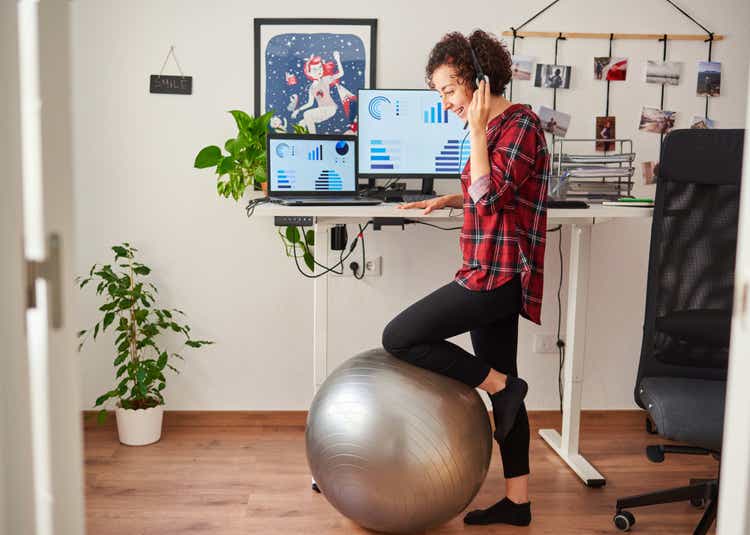 Person on a call leaning on a yoga ball.