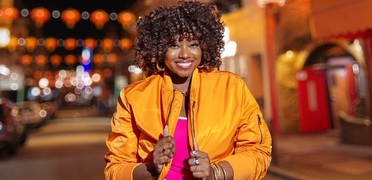 Photograph of model in an orange jacket.