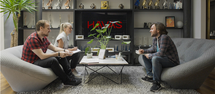 Group of three people sitting around a table.