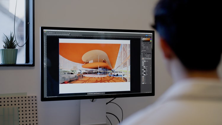 Man working in Adobe Photoshop on desktop computer