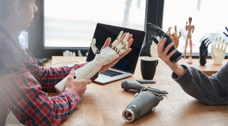 Two people working on a project building a bionic hand.