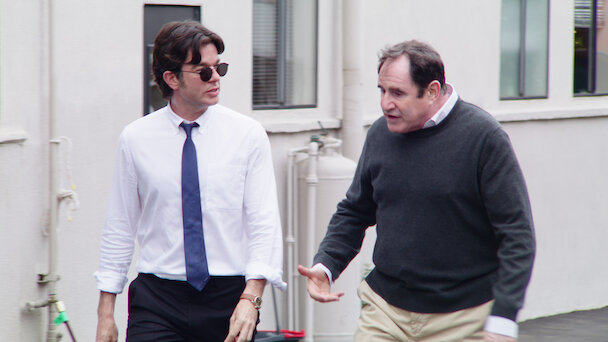 Image of John Mulaney walking with another man.