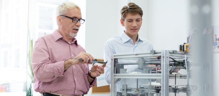 Two men from Haileybury working on a machine.