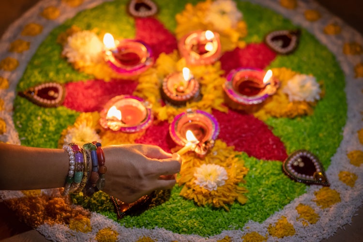 Person with match lighting candles for Diwali