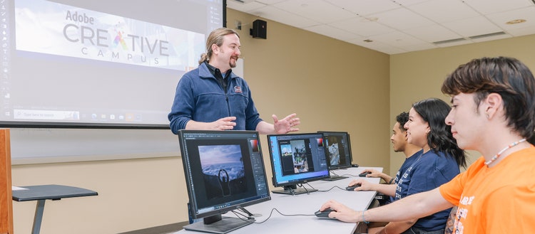 Teacher helping students unlock career opportunities with Adobe Creative Skills micro-credentials.