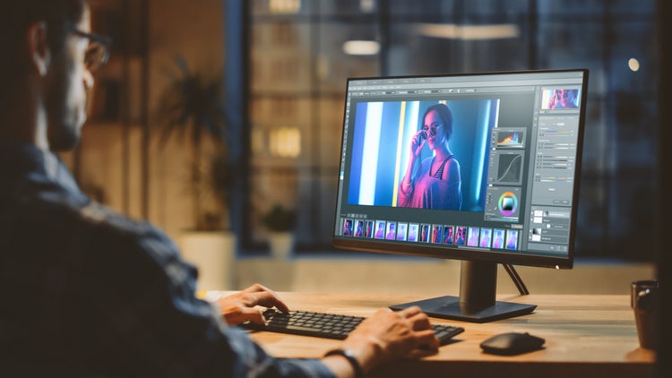 Man editing picture of women in Phooshop on Desktop computer