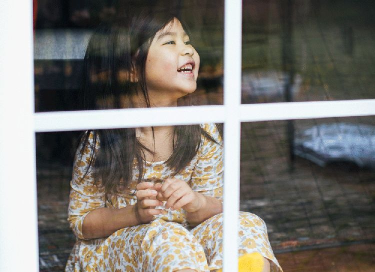 Young girl behind a window.