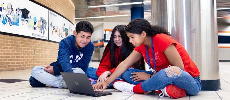 Three kids around a laptop.