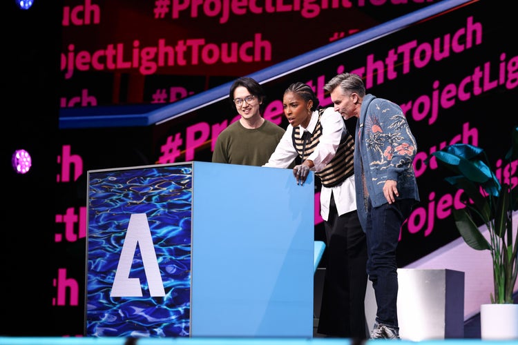 Three people on stage at Adobe MAX