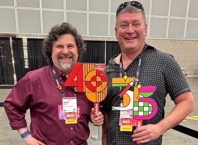 Adobe Certified Expert Jason Hoppe (right) with their anniversary pins and signs at Adobe MAX 2025.