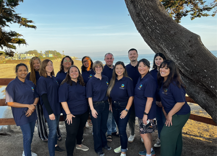 Community members standing in front of the ocean.