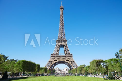 Eiffel tower, sunny summer day with blue sky and green Field of Mars
